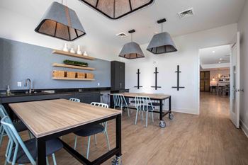 A dining room with tables and chairs and a kitchen